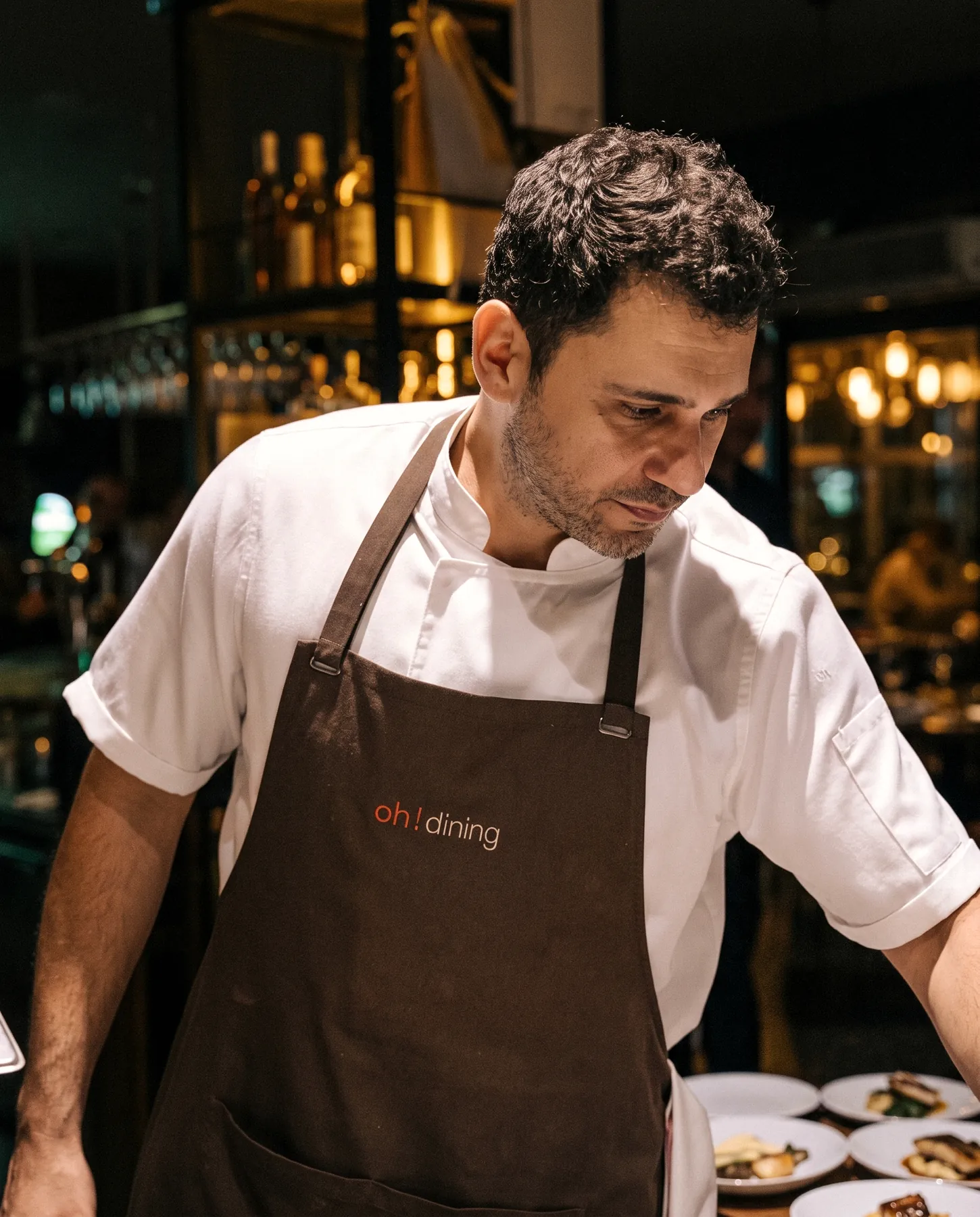 Chef Hakan Öztaç plating at the pass during service